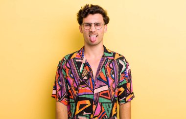 Genç yakışıklı adam tiksinmiş ve rahatsız olmuş hissediyor. Dilini dışarı çıkarıyor. İğrenç ve iğrenç bir şeyden hoşlanmıyor.