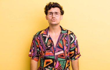 Genç yakışıklı adam dudaklarını birbirine bastırıyor, tatlı, eğlenceli, mutlu, sevimli bir yüz ifadesiyle, öpücük yolluyor.