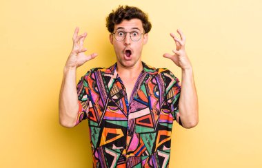 Genç yakışıklı adam elleri havada bağırıyor, öfkeli, sinirli, stresli ve üzgün hissediyor.