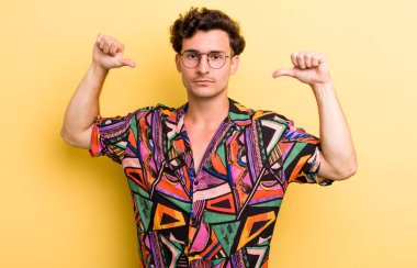 Genç yakışıklı adam gururlu, kibirli ve kendinden emin, tatmin olmuş ve başarılı görünüyor, kendini işaret ediyor.