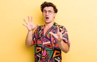 Dehşete kapılmış genç yakışıklı bir adam korku ve panik içinde geri çekiliyor ve bir kabusa tepki veriyor.