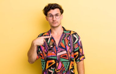 Kafası karışmış, kafası karışmış ve kendine güveni olmayan genç yakışıklı bir adam kendini göstererek kim olduğunu soruyor, ben mi??