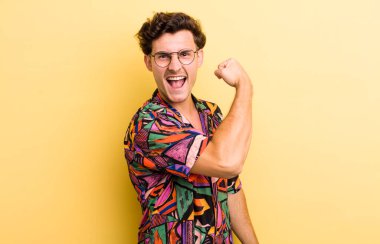 Genç yakışıklı adam kendini mutlu, tatmin olmuş ve güçlü hissediyor, kaslı ve formda, spor salonundan sonra güçlü görünüyor.