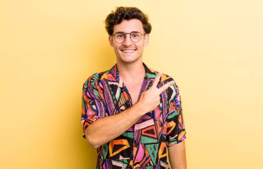 Genç yakışıklı adam kendini mutlu, pozitif ve başarılı hissediyor. Göğsünde el ile V şekli yapıyor. Zafer ya da huzur gösteriyor.