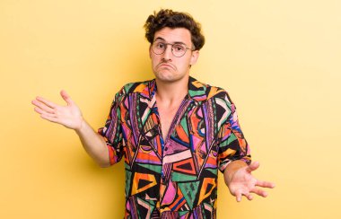 Genç yakışıklı adam şaşkın ve şaşkın hissediyor, doğru cevap veya karardan emin değil, bir seçim yapmaya çalışıyor.