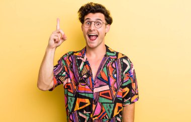Genç yakışıklı bir adam bir fikri fark ettikten sonra mutlu ve heyecanlı bir dahi gibi hissediyor, neşeli bir şekilde parmağını kaldırıyor, eureka!