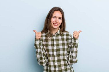 Genç ve güzel bir kadın neşeyle gülümsüyor ve mutlu görünüyor, kaygısız ve pozitif hissediyor.