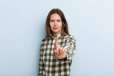 Genç ve güzel bir kadın gururla gülümsüyor ve gururla bir numaralı pozu veriyor, kendini lider gibi hissediyor.