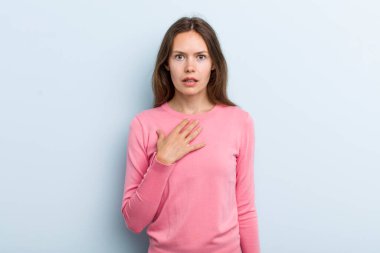 Genç ve güzel bir kadın şaşkın, şaşkın ve şaşırmış hissediyor, elleri göğsünde ve ağzı açık, kim olduğumu söylüyor, ben?