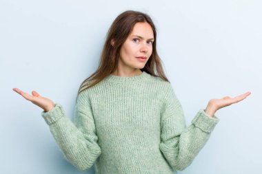 Şaşkın, kafası karışmış ve stresli görünen genç ve güzel bir kadın. Farklı seçenekler arasında merak ediyor. Belirsiz hissediyor.