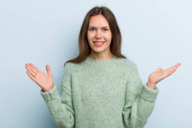 Genç, güzel bir kadın mutlu, heyecanlı, şaşırmış ya da şok olmuş, gülümseyen ve hayrete düşmüş.