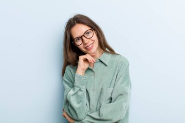 Genç ve güzel bir kadın gülümsüyor, hayattan zevk alıyor, mutlu, arkadaş canlısı, tatmin olmuş ve tasasız.