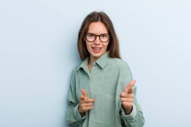 Genç ve güzel bir kadın kendini mutlu, sakin, tatmin olmuş, rahat ve başarılı hissediyor. Kameraya bakıyor ve seni seçiyor.