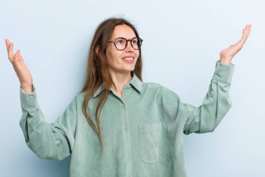 Genç, güzel bir kadın kendini mutlu, şaşkın, şanslı ve şaşırmış hissediyor. Zaferi iki eli havada kutluyor.