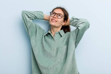 Genç ve güzel bir kadın gülümsüyor ve rahatlıyor, tatmin oluyor ve kaygısızca gülüyor.