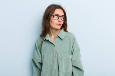 Genç, güzel bir kadın mutlu düşünceler ve fikirler düşünüyor, hayal kuruyor, kenarda yer arıyor.