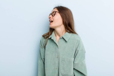 Genç ve güzel bir kadın öfkeyle bağırıyor, agresif bir şekilde bağırıyor, stresli ve kızgın görünüyor.