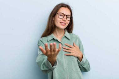 Genç ve güzel bir kadın mutlu ve aşık, bir eli kalbinin yanında gülümsüyor ve diğer eli önde uzanıyor.