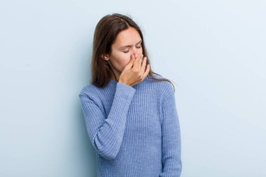 Genç ve güzel bir kadın iğreniyor, kötü ve nahoş bir koku duymamak için burnunu tutuyor.