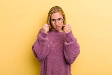 Genç, sarışın, kendine güvenen, sinirli, güçlü ve agresif bir kadın. Yumrukları boks pozisyonunda dövüşmeye hazır.