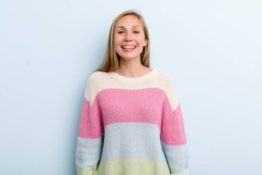 young adult blonde pretty woman looking happy and goofy with a broad, fun, loony smile and eyes wide open