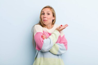 young adult blonde pretty woman feeling confused and clueless, wondering about a doubtful explanation or thought