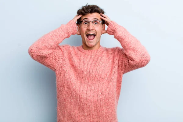 Genç yakışıklı adam el ele tutuşuyor, ağzı açık, son derece şanslı, şaşırmış, heyecanlı ve mutlu hissediyor.