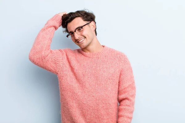 Genç yakışıklı adam neşeyle ve tesadüfen gülümsüyor, olumlu, mutlu ve kendinden emin bir bakışla göğüs göğüse.