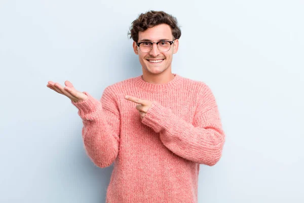 Joven Hombre Guapo Sonriendo Alegremente Apuntando Copiar Espacio Palma Mano —  Fotos de Stock