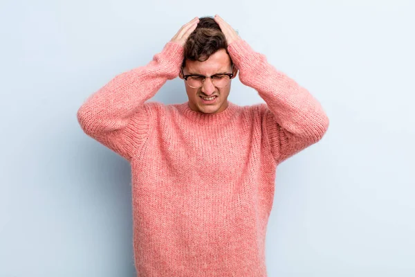 Genç ve yakışıklı bir adam stresli ve hayal kırıklığına uğramış hissediyor. Yumruk yumruğa, yorgun, mutsuz ve migren ağrısı çekiyor.