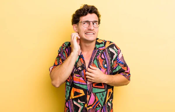 Genç ve yakışıklı bir adam stresli, hayal kırıklığına uğramış ve yorgun, endişeli ve sorunlu bir bakışla boynunu okşuyor.