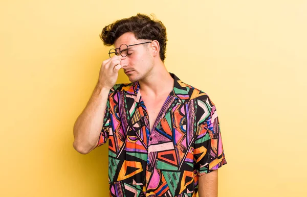 Genç yakışıklı, stresli, mutsuz ve hayal kırıklığına uğramış, alınlı ve şiddetli baş ağrısı çeken bir adam.