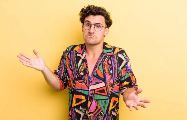 Genç yakışıklı adam şaşkın ve şaşkın hissediyor, doğru cevap veya karardan emin değil, bir seçim yapmaya çalışıyor.