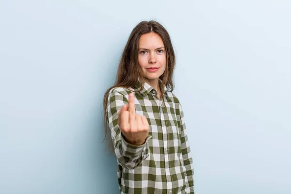 young adult pretty woman feeling angry, annoyed, rebellious and aggressive, flipping the middle finger, fighting back