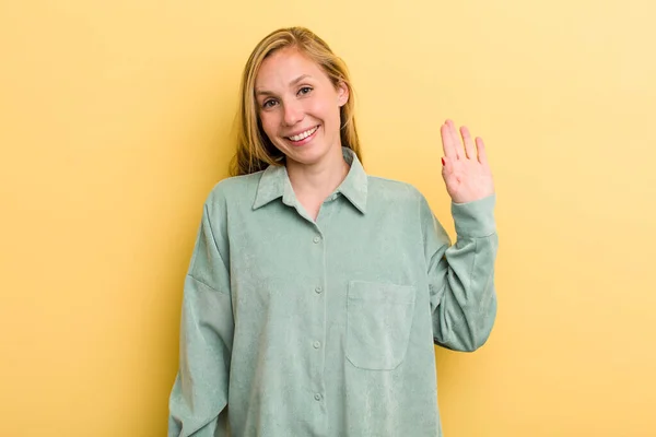 Young Adult Blonde Pretty Woman Smiling Happily Cheerfully Waving Hand — Stockfoto