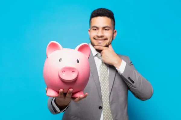 Hispanic Businessman Thinking Expression Holding Piggy Bank — Stok fotoğraf