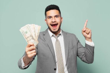 hispanic businessman celebrating successful a victory and holding dollar banknotes
