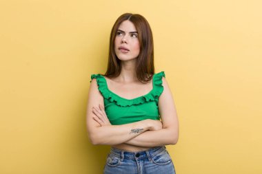 Genç ve güzel bir kadın şüpheye düşüyor ya da düşünüyor, dudağını ısırıyor ve kendini güvensiz ve gergin hissediyor, kenarda yer arıyor.