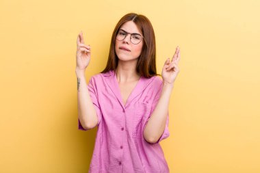 Genç ve güzel bir kadın endişeyle dua ediyor ve endişeli bir bakışla iyi şanslar diliyor.