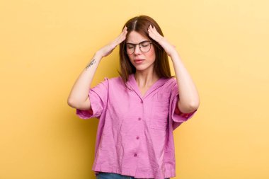 Genç ve güzel bir kadın stresli ve hayal kırıklığına uğramış görünüyor, baskı altında çalışıyor ve başı ağrıyor.