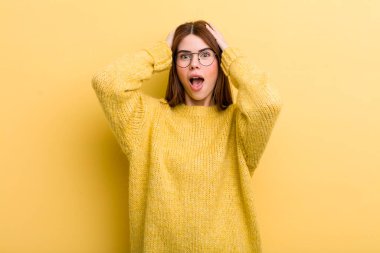 Genç ve güzel bir kadın el ele tutuşuyor, ağzı açık, son derece şanslı, şaşırmış, heyecanlı ve mutlu.