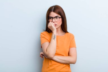 young adult pretty woman feeling serious, thoughtful and concerned, staring sideways with hand pressed against chin