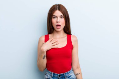 Genç ve güzel bir kadın şaşkın, şaşkın ve şaşırmış hissediyor, elleri göğsünde ve ağzı açık, kim olduğumu söylüyor, ben?