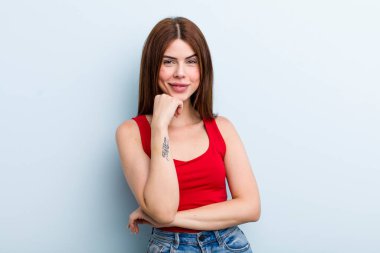 Genç ve güzel bir kadın gülümsüyor, hayattan zevk alıyor, mutlu, arkadaş canlısı, tatmin olmuş ve tasasız.