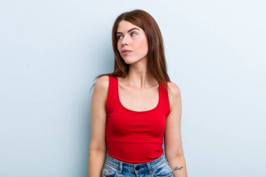 Genç, güzel bir kadın mutlu düşünceler ve fikirler düşünüyor, hayal kuruyor, kenarda yer arıyor.