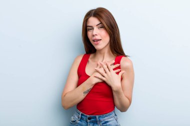 Genç ve güzel bir kadın romantik, mutlu ve aşık, neşeyle gülümseyen ve kalbe yakın el ele tutuşan