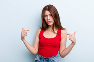 Genç ve güzel bir kadın gururlu, pozitif ve iki eliyle göğsünü gösteren.