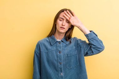 Genç ve güzel bir kadın stresli görünüyor, yorgun ve hayal kırıklığına uğramış, alnından ter damlıyor, umutsuz ve bitkin hissediyor.