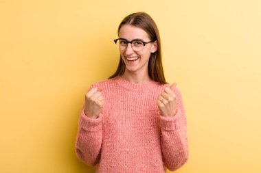 Genç ve güzel bir kadın zaferle bağırıyor, gülüyor, mutlu ve heyecanlı hissediyor başarıyı kutlarken.