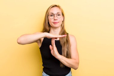 Genç sarışın kadın ciddi, sert, kızgın ve hoşnutsuz görünüyor.